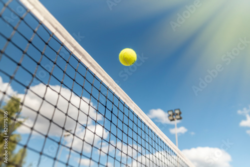tennis background Close-up shots of tennis balls in tennis courts With a mesh as a blurred background And the light shining on the ground makes the image beautiful © Iliya Mitskavets