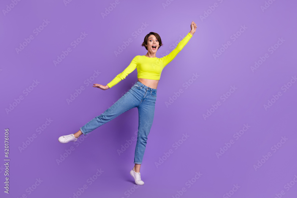 Obraz premium Full body photo of cheerful pretty lady dancing hand hold empty space umbrella isolated on violet color background