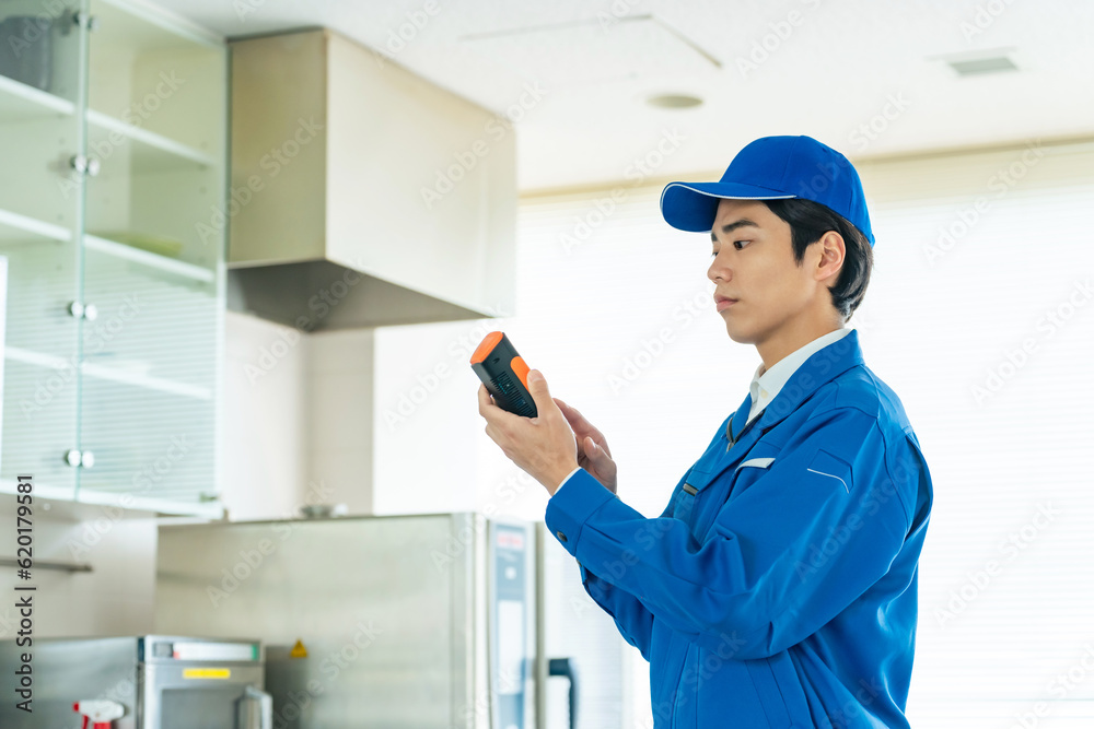ポータブル測定器で室内環境を計測する作業員 ポータブル測定器で室内環境を計測する作業員