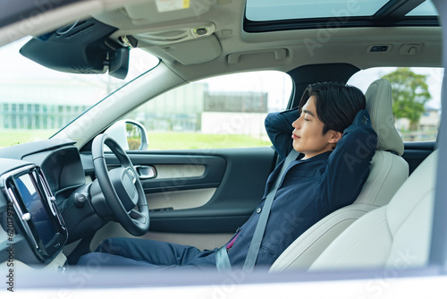 自動車の車内で眠るドライバー　自動運転　休憩　車中泊 © metamorworks
