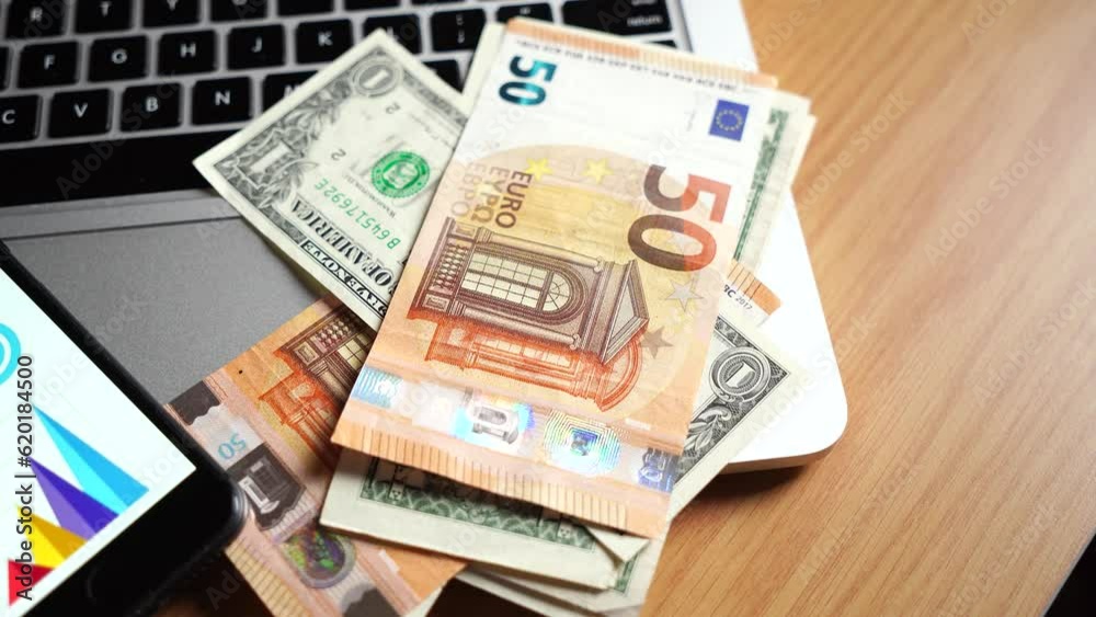 Dollar and euro bills on a laptop. Investments and assets with the help of the Internet. Dollar and euro bills on a laptop. Investments and assets with the help of the Internet.