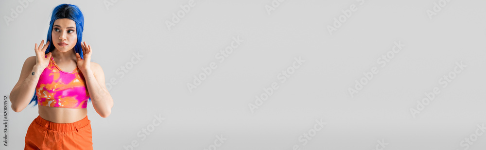 modern individual, tattooed young woman with blue hair posing with hands near face on grey background, modern style, urban fashion, vibrant color, female model, looking away, banner modern individual, tattooed young woman with blue hair posing with hands near face on grey background, modern style, urban fashion, vibrant color, female model, looking away, banner