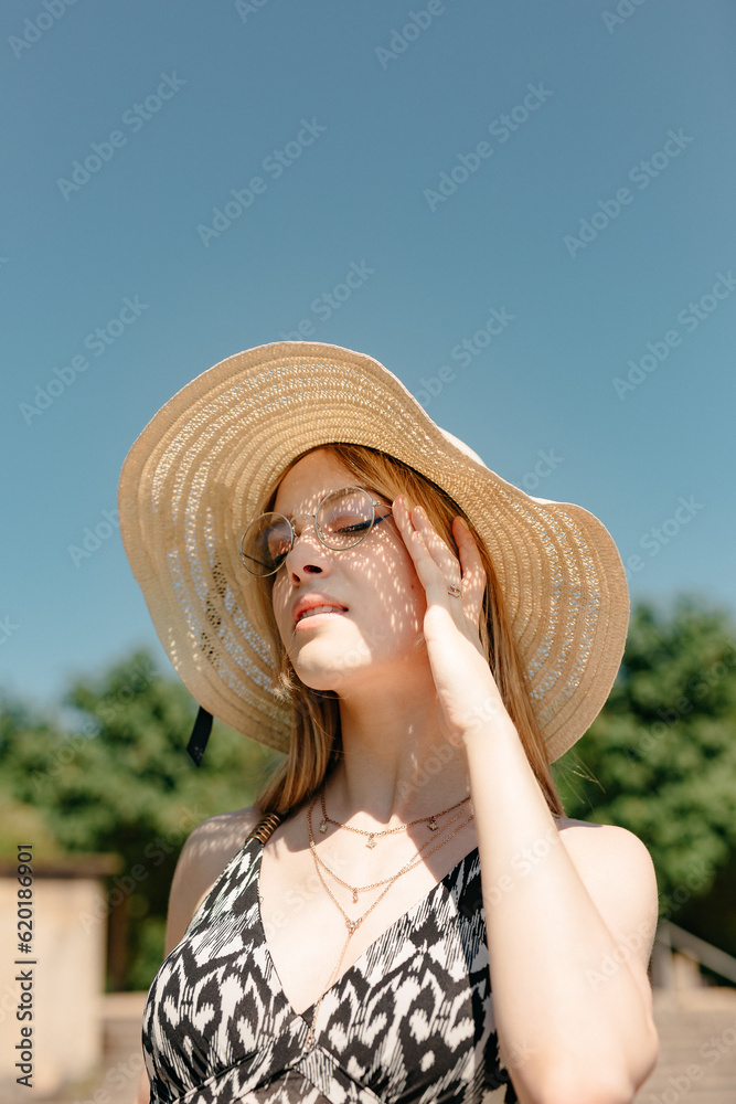 Young woman protecting herself from sun with straw hat