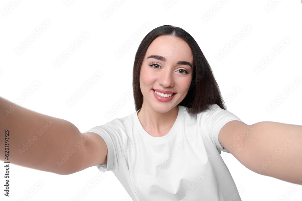 Smiling young woman taking selfie on white background