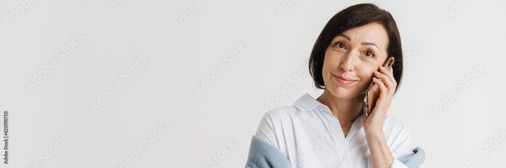 European mature woman smiling and talking on mobile phone European mature woman smiling and talking on mobile phone