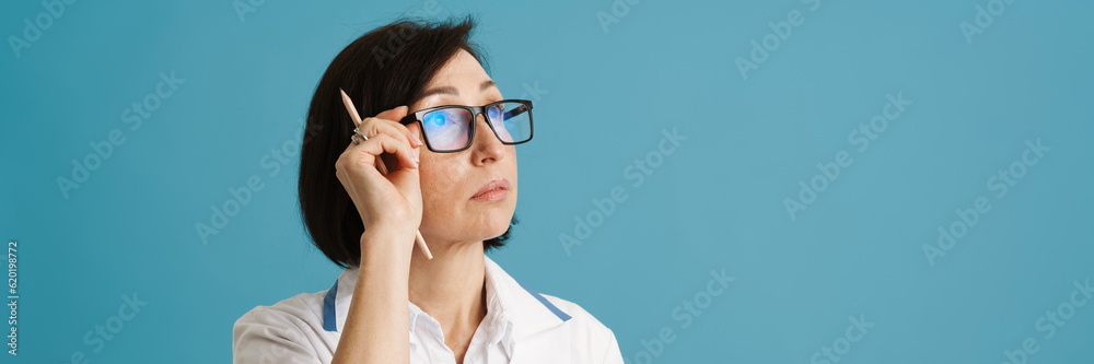 European mature doctor looking aside while posing with clipboard European mature doctor looking aside while posing with clipboard