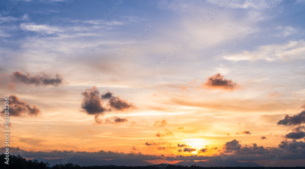 Sunset sky clouds in the evening with orange sunlight over hill, Landscape horizon dusk sky in summer 