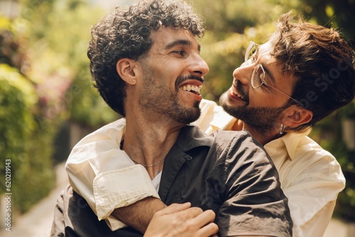 Happy gay couple hugging in the park. LGBT gay couple concept.