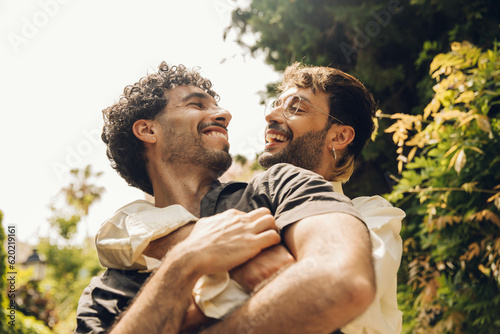 Happy gay couple hugging in the park. LGBT gay couple concept.