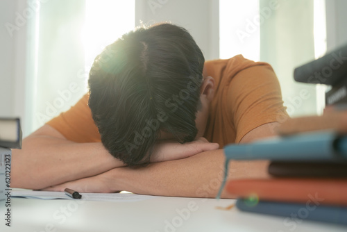 Asian student man have anxiety because of exams, male prepare for test and learning lessons in the library. stress, despair, haste, misunderstanding reading, discouraged, expectation, knowledge