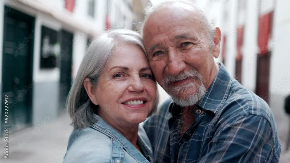 Happy multiracial senior couple hugging each other with city on background - Elderly people relationship family concept Happy multiracial senior couple hugging each other with city on background - Elderly people relationship family concept