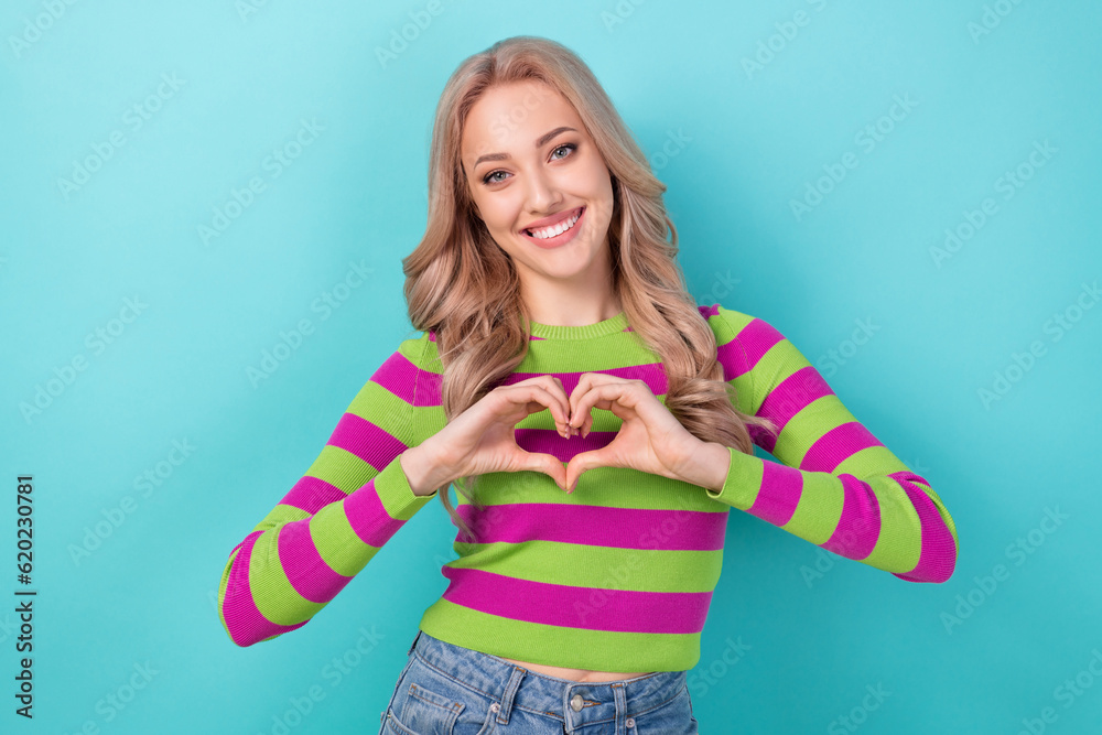 Portrait of cheerful appreciative girl with wavy hairdo wear stylish clothes fingers show heart symbol isolated on blue color background Portrait of cheerful appreciative girl with wavy hairdo wear stylish clothes fingers show heart symbol isolated on blue color background