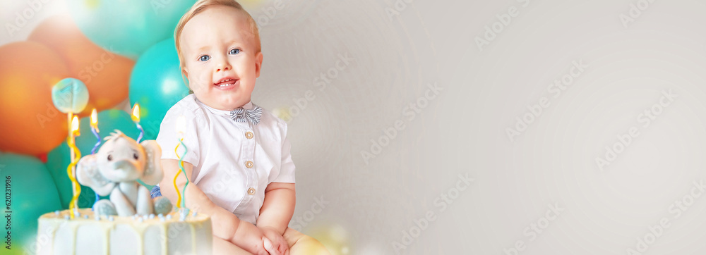 Banner of little boy (1-year-old) with delicious birthday cake (sweets with candles of number one, decoration). Celebrating child's first year birthday. Copy space. Empty space for your message. Banner of little boy (1-year-old) with delicious birthday cake (sweets with candles of number one, decoration). Celebrating child's first year birthday. Copy space. Empty space for your message.