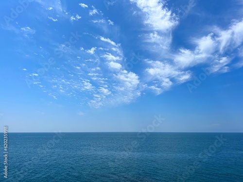 Blue sea, sky, clouds, horizon, calm water. © OLENA