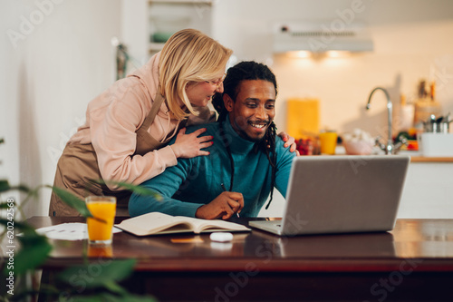 An interracial remote worker at home with his wife. © Zamrznuti tonovi