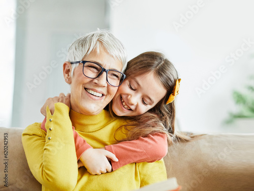 grandchild family child grandparent grandmother book reading elderly granddaughter girl happy together read learning education story fun leisure teaching storytelling senior smiling kiss hug photo