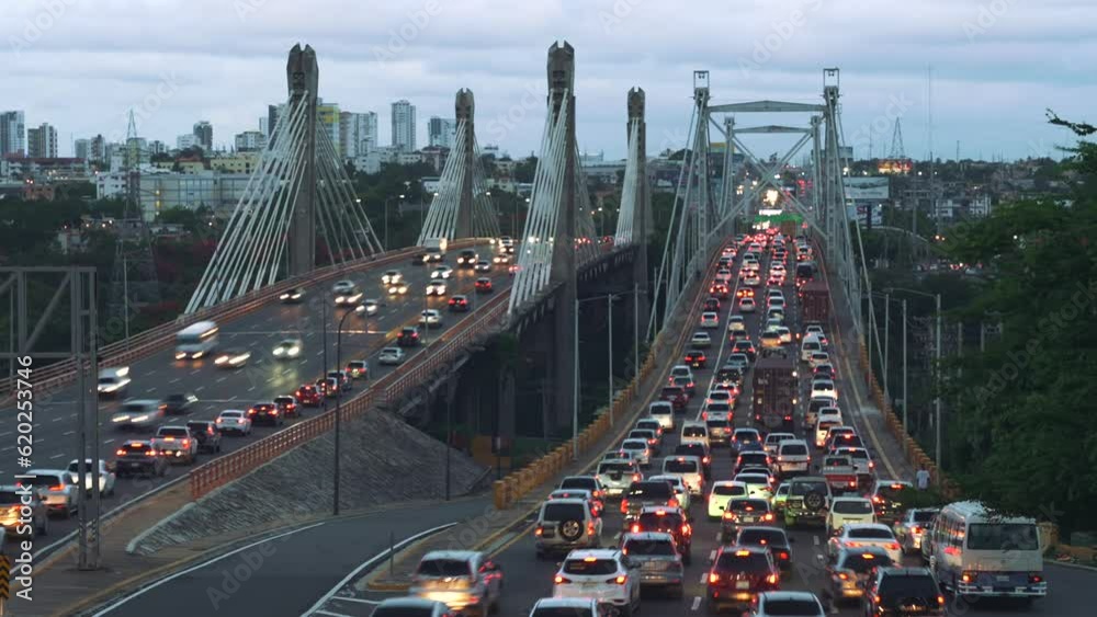 Timelapse of many cars and trucks with stop lights driving fast on speed multi lane highway Juan Bosch Bridge at night in Santo Domingo. Blur motion city traffic jam background