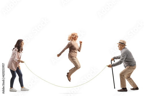 Elderly father playing skipping rope with his daughters