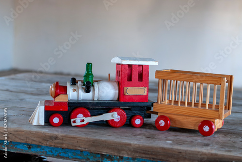 Children's wooden toy. An old wooden train full of color abandoned on a table.
