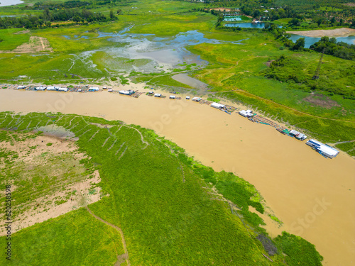 Aerial view of National Route 20 in Dong Nai province, group of floating house on La Nga river, Vietnam with hilly landscape and sparse population around the roads. photo