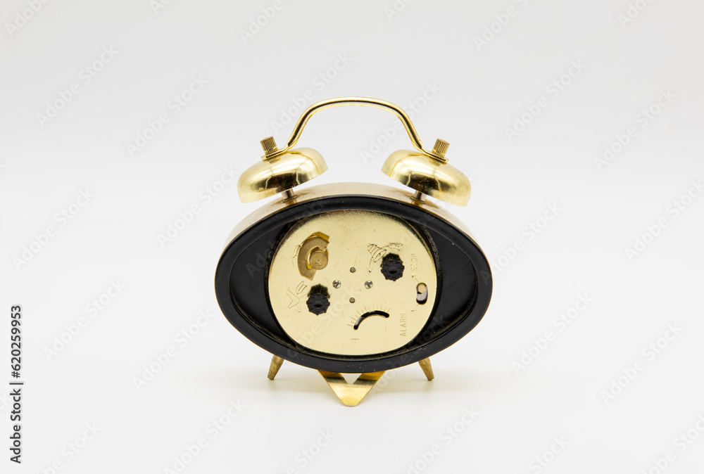 Reloj despertador de doble campana con cara triste, aislado en blanco Reloj despertador de doble campana con cara triste, aislado en blanco