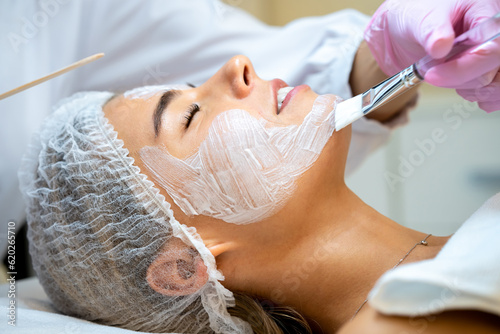 Cosmetologist doing cleansing beauty procedures in clinic, peeling and anti aging.