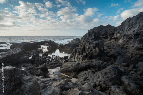 Long exposure. rocky beach with a natural arch with blue sky. Charco Azul. El Hierro island. Canary Islands 