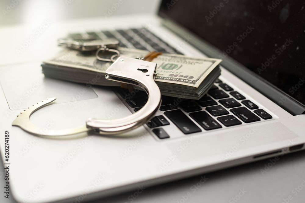 Handcuffs and dollars on keyboard, top view. Handcuffs and dollars on keyboard, top view.