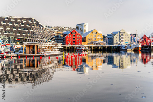 Colorful houses by the harbor mirrored in the cold sea at dawn, Tromso, Norway, Scandinavia photo