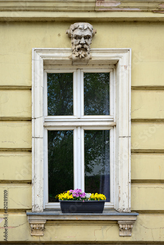 Der Charme vergangener Zeiten: altes Holzfenster mit klassizistischen Schmuckelementen an einer heruntergekommenen Hausfassade in der historischen Altstadt von Beelitz
