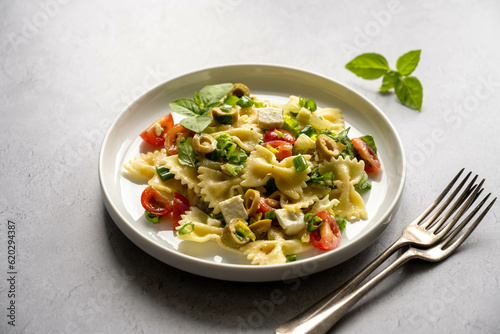 Pasta salad. Traditional Italian pasta with cherry tomatoes, olives, feta cheese, green cabbage.