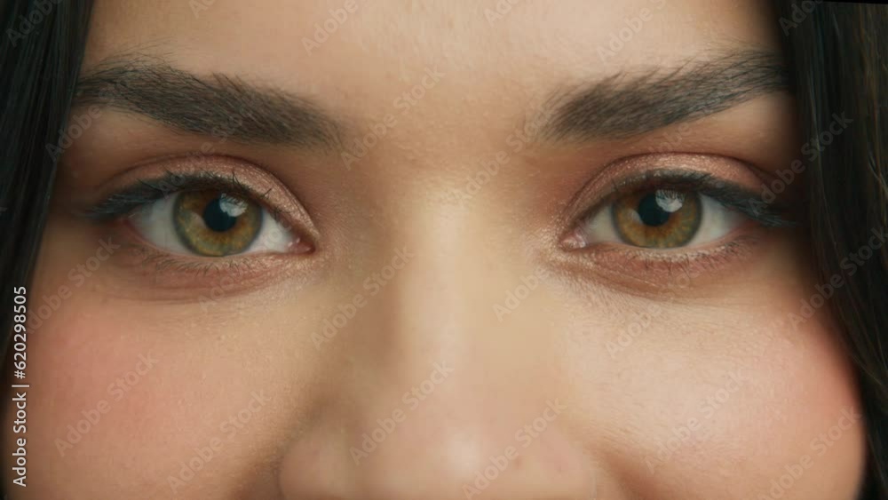 Close-up of hazelnut green eyes and face of young beautiful woman. Slow motion zoom in green brown eyeball iris. Good vision, I see you, the eye is the mirror to one's soul concept. looking at camera