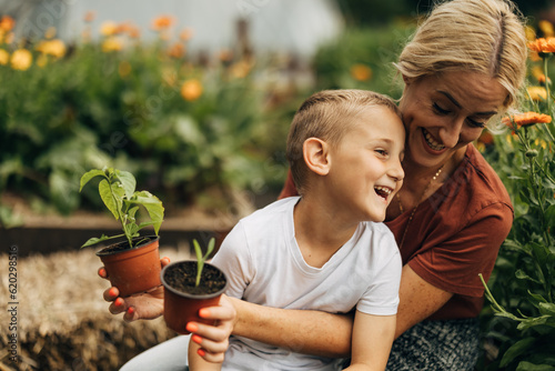 A blond woman and her adorable son have fun in the garden.