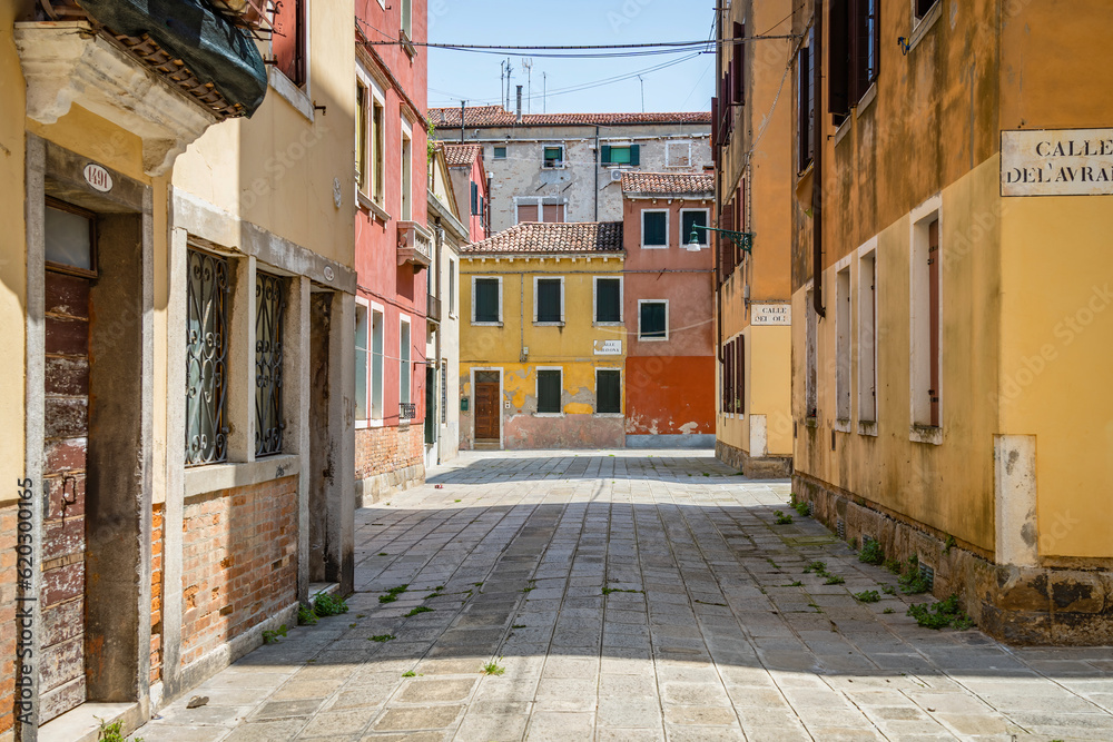 Scene with the narrow streets and the old medieval red brick buiuldings in Venice, Italy.