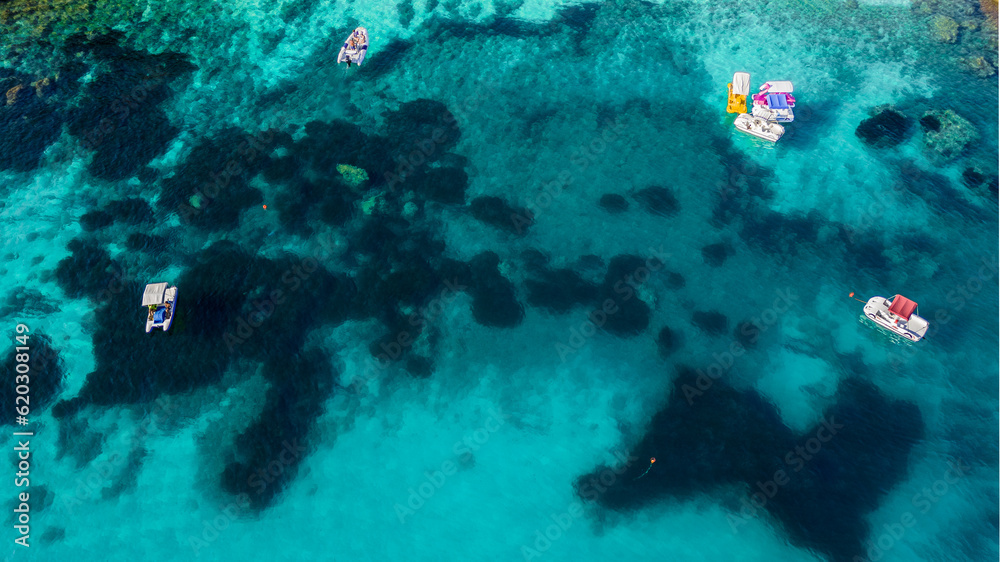 Fototapeta premium aerial view from the drone of a crystal clear Caribbean sea with boats that seem to fly. this image gives a sense of peace and tranquility immersed in unspoiled nature