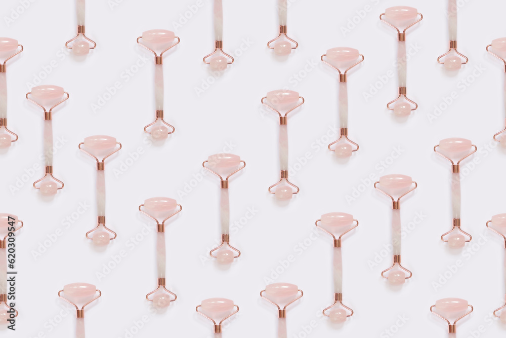 Creative pattern from the facial massage set for home spa. Facial roller made of rose quartz on a light background. The concept of natural treatment Creative pattern from the facial massage set for home spa. Facial roller made of rose quartz on a light background. The concept of natural treatment