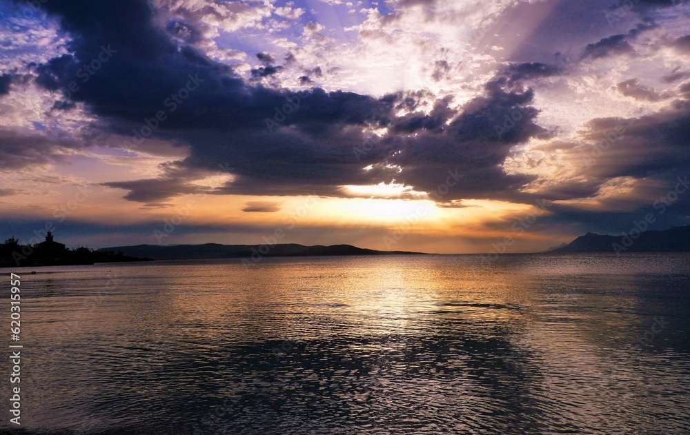 Sunset above the sea with dramatic clods