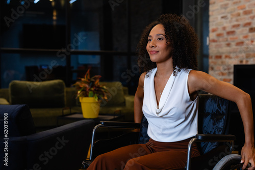 Happy african american casual businesswoman in wheelchair in office © wavebreak3