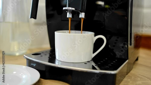 Coffee machine filling a cup with. Making coffee into cup, espresso coming out from an automated coffee maker machine. Beverage drink for breakfast, lunch