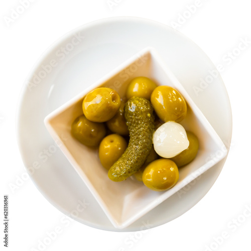 Large green olives on platter with pickled garlic and cucumbers. Isolated over white background