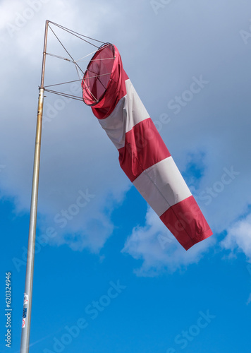 Windsock during a strong wind. Windsock shows wind direction and strength. Made of fabric in the form of a cone. It is installed at the airports of small aircraft or on the basis of sailing ships
