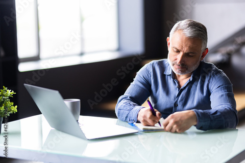 Middle-aged man working from home office on laptop
