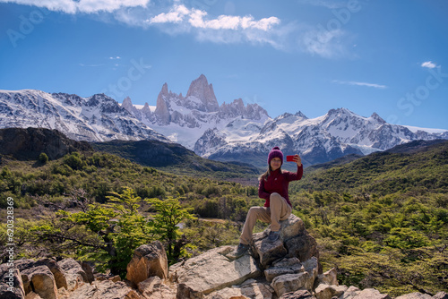 Woman sitting on the point view of Mount Fitz Roy making a selfie