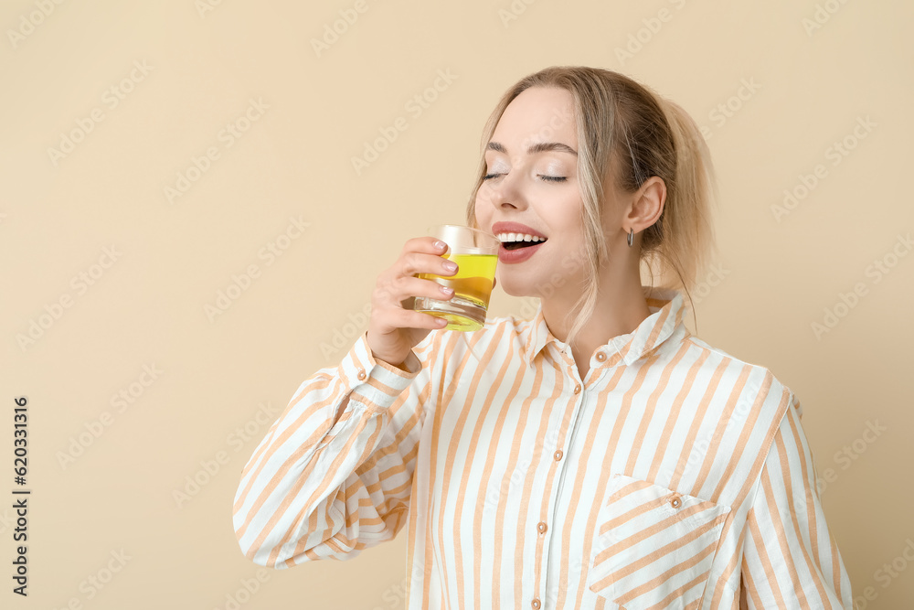 Young woman with dissolved tablet in glass of water on beige background Young woman with dissolved tablet in glass of water on beige background