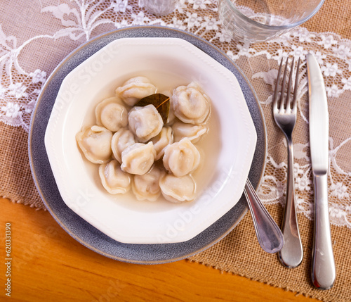 Delicious Russian pelmeni filled with meat traditionally served in broth. Popular comfort food ..