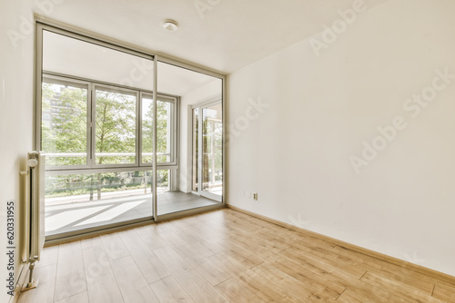 an empty room with wood floors and large windows in the middle part of the apartment there is a sliding glass door