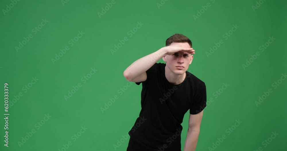A focused man gazes into the distance on a green background. His expression is intense and determined, with his eyebrows slightly raised and his eyes fixated on a point in the distance. A focused man gazes into the distance on a green background. His expression is intense and determined, with his eyebrows slightly raised and his eyes fixated on a point in the distance.