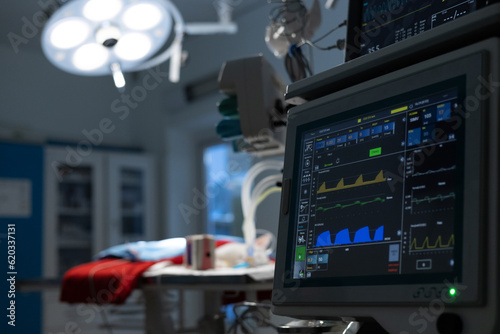 Konstfotografi Against the background of dark surgery in the light of a lamp a pet lies on the table and there is a monitor showing the life indicator After the operation the pet lies under the control of monitors