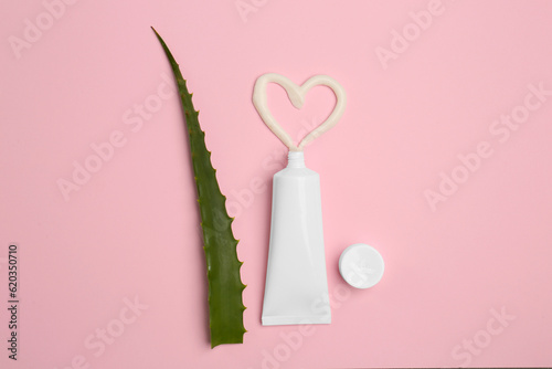 Tube of toothpaste and fresh aloe on pink background, flat lay © New Africa