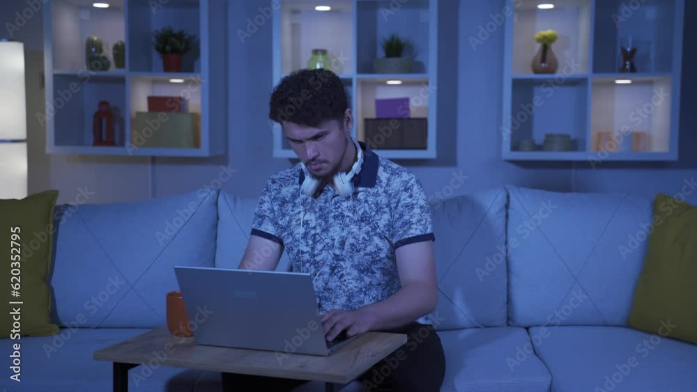 Happy man using laptop at night. Happy man using laptop at night.